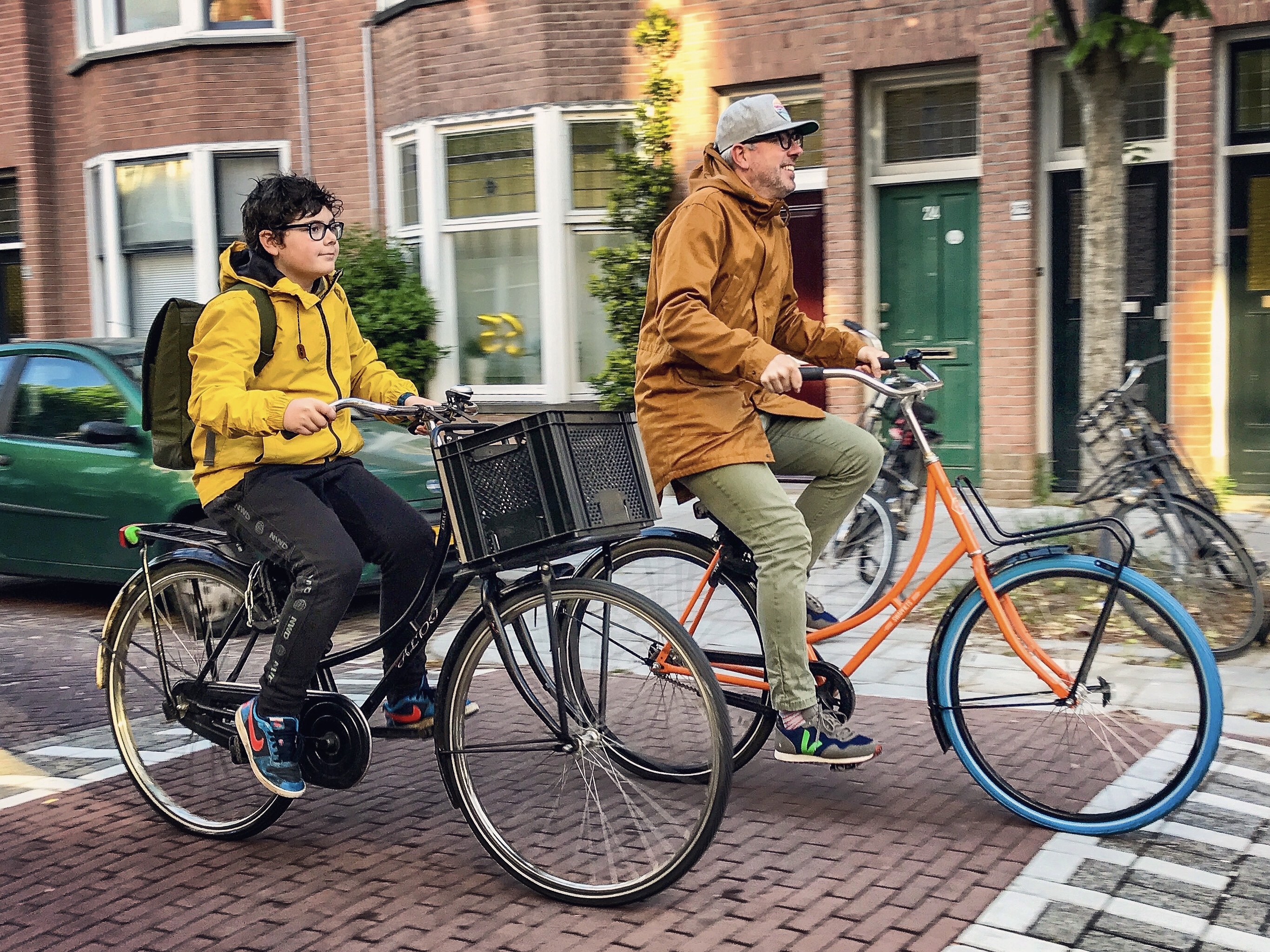 Chris Bruntlett and his son cycle next to each other on a Dutch street 