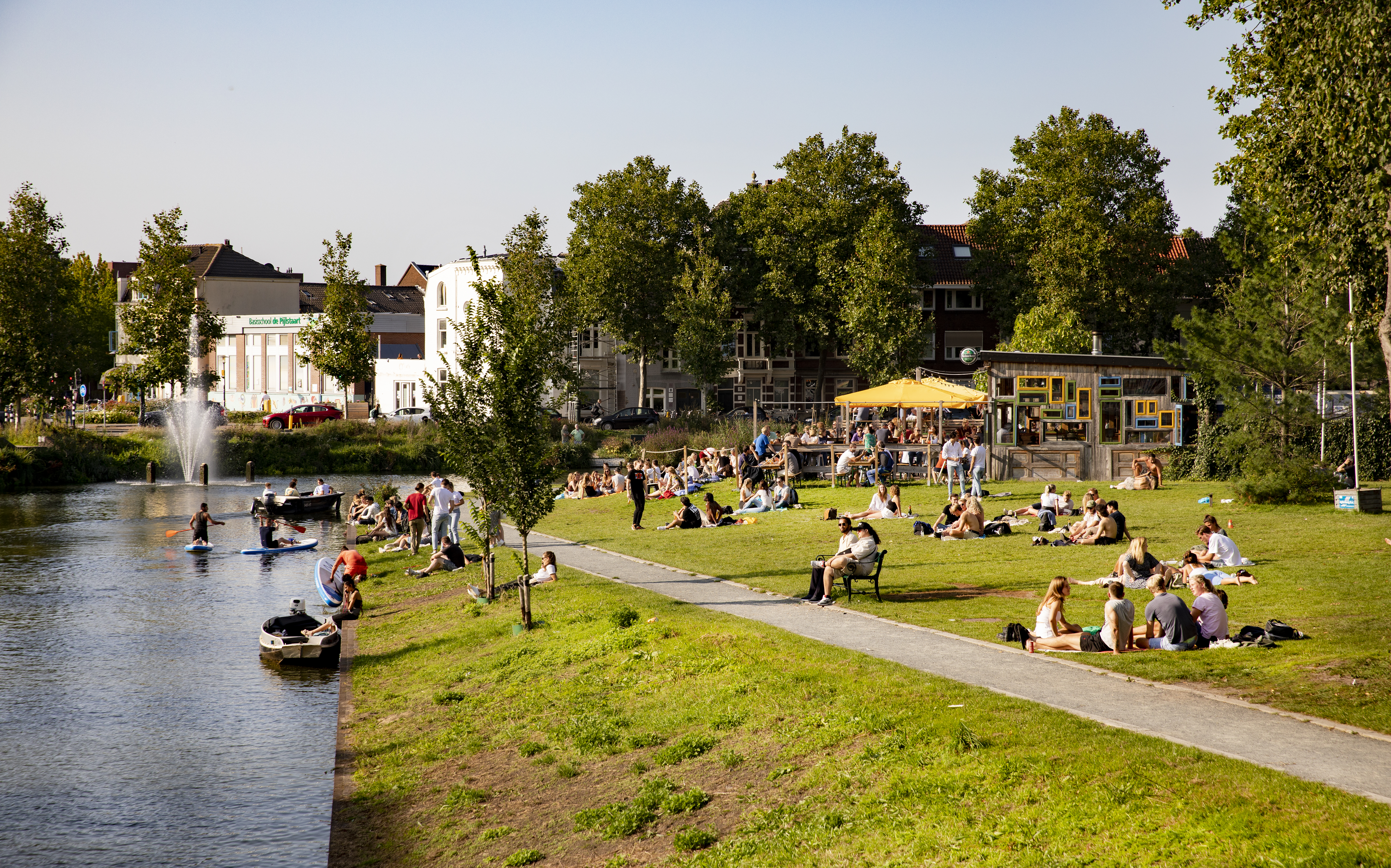 students on a lawn by a canal