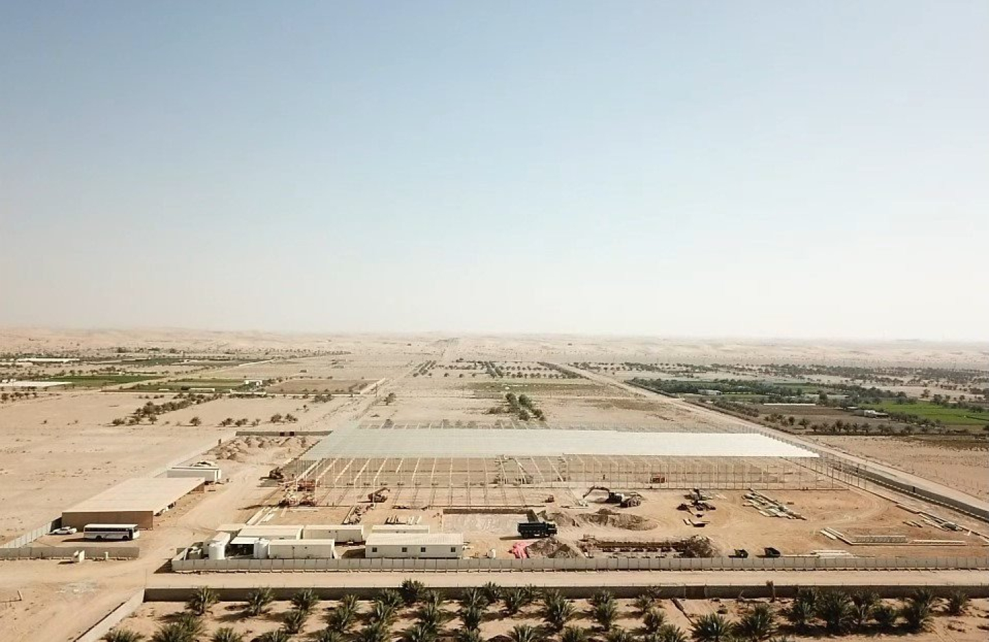 a large tract of desert land with greenery and crops growing between it