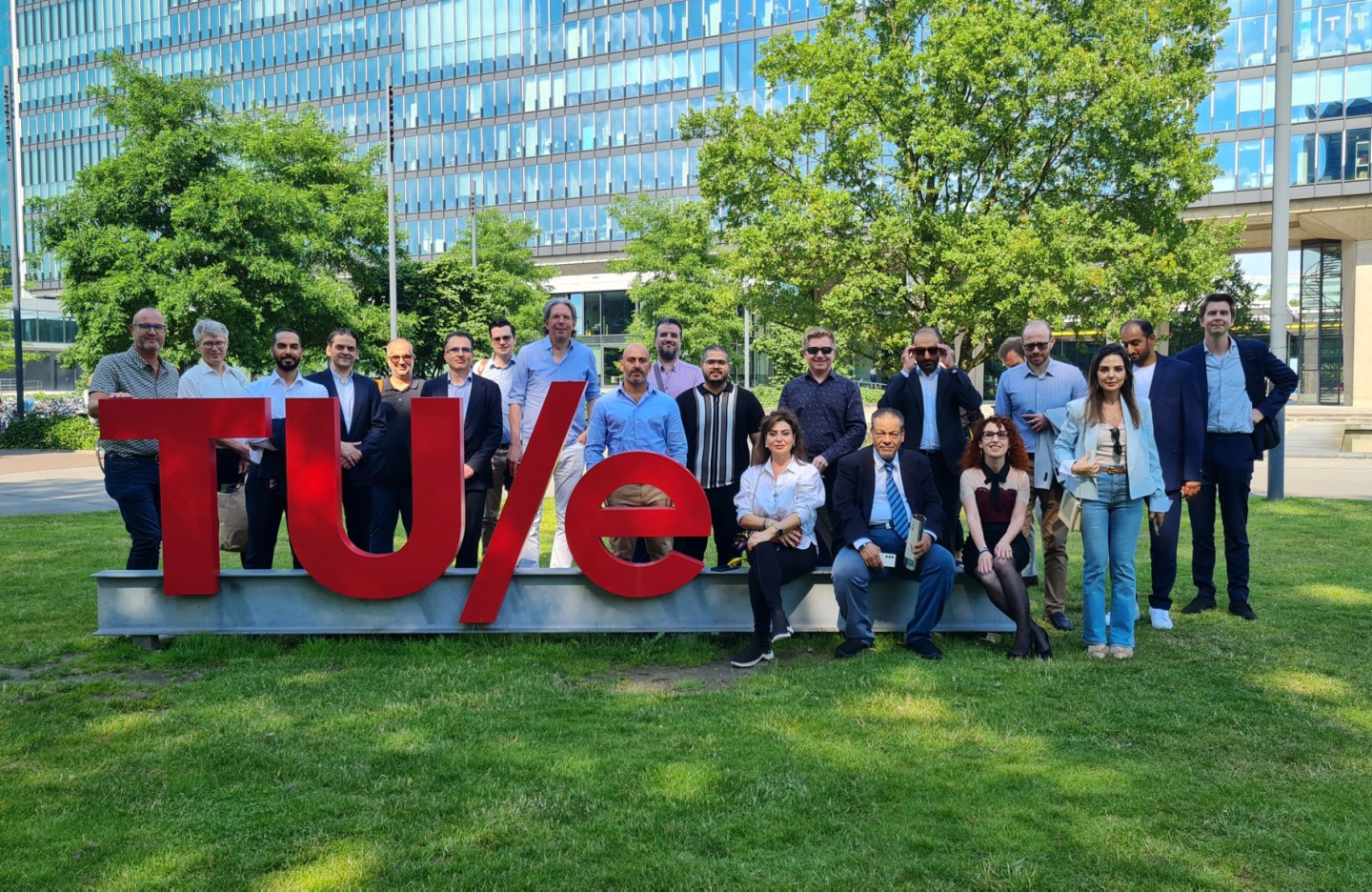 cluster partners pose in a group in front of the TU/e sign