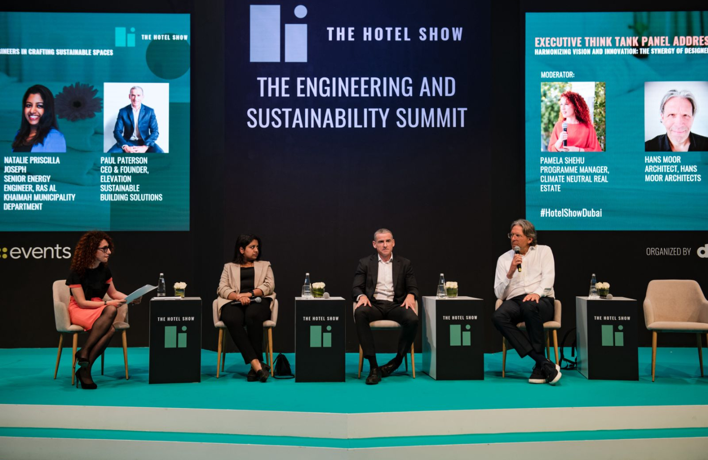 cluster members sit in a panel on a stage at a conference