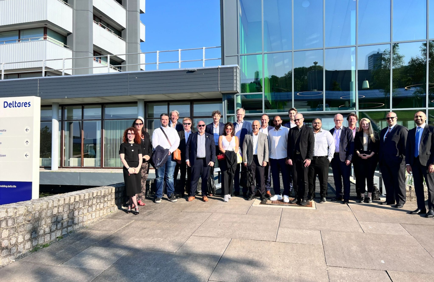 cluster members stand outdoors in the sunshine and pose for a group image