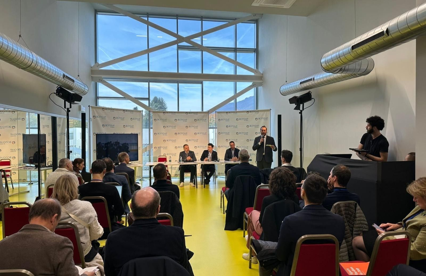 people on a trade mission to italy watch a talk in a conference room