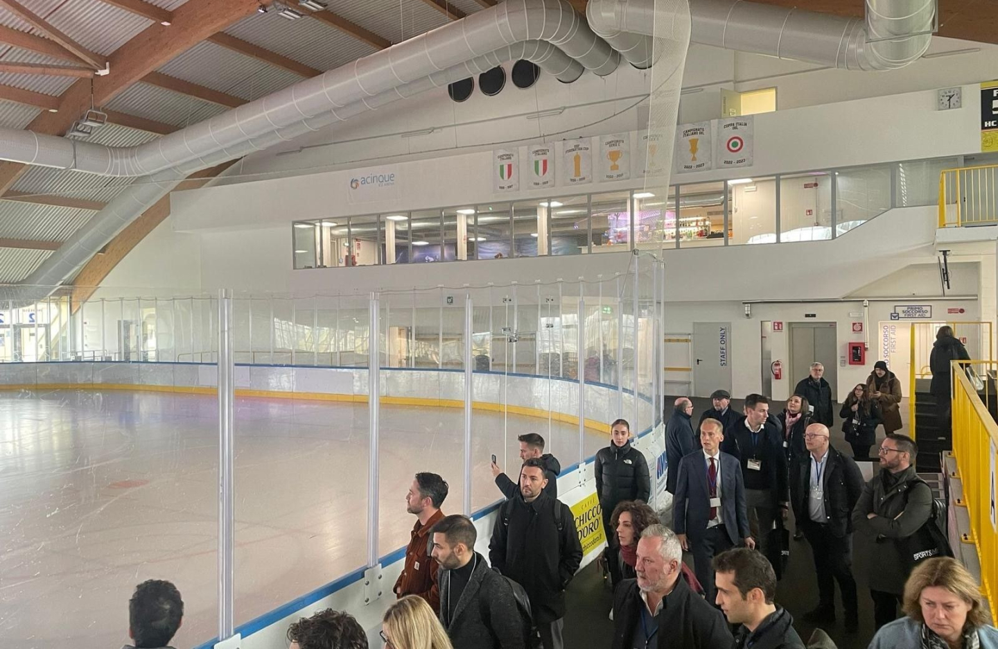 people on a trade mission to italy look at an ice skating rink