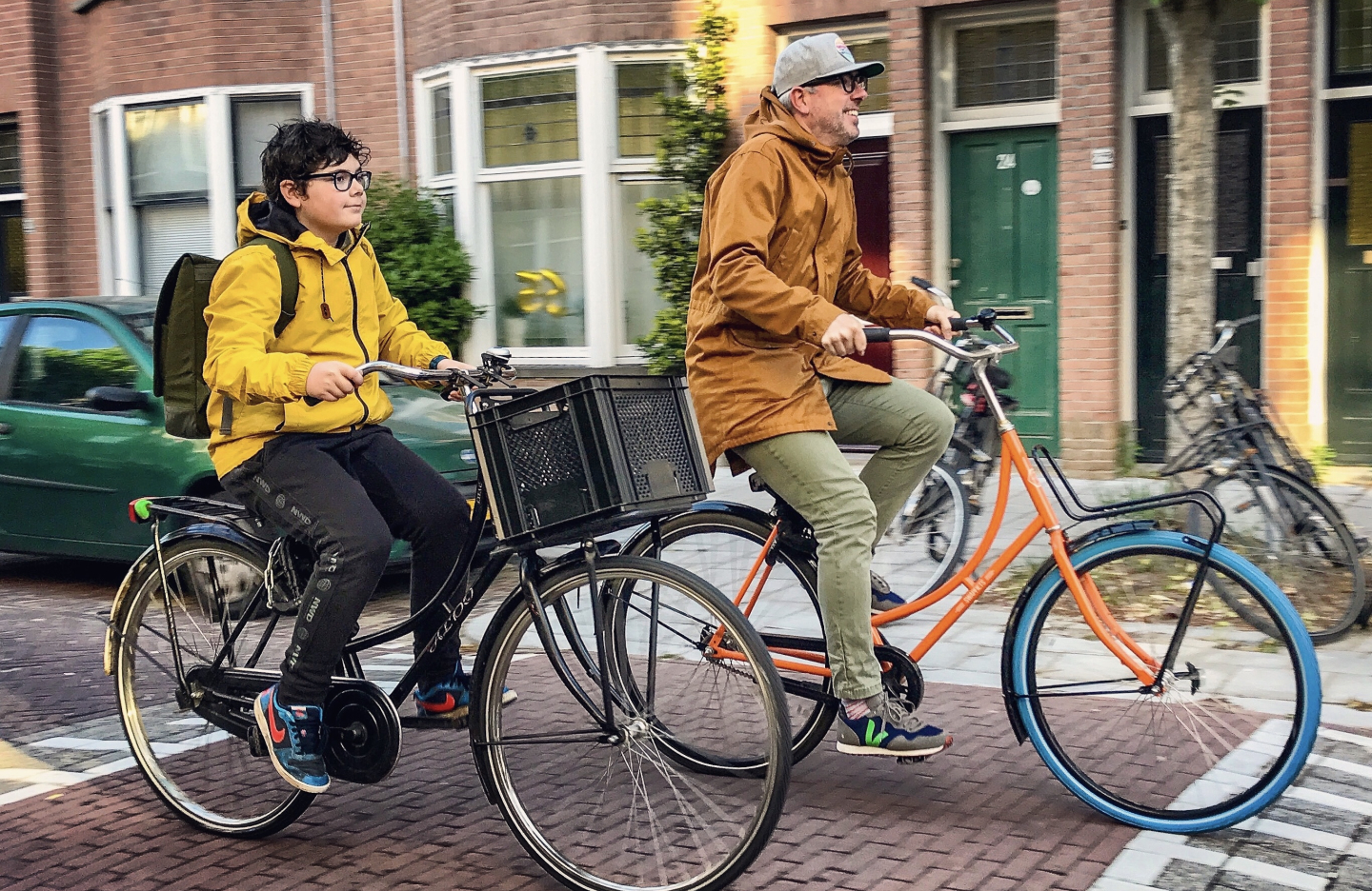 Chris Bruntlett and his son cycle next to each other on a Dutch street 