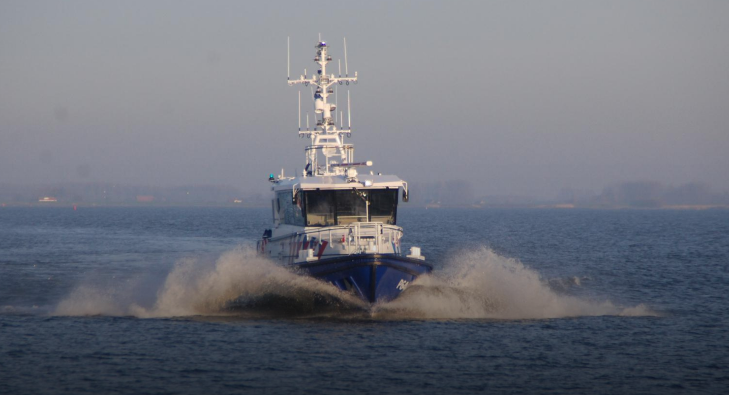 A defence ship with antennas and technology cruises through an open ocean