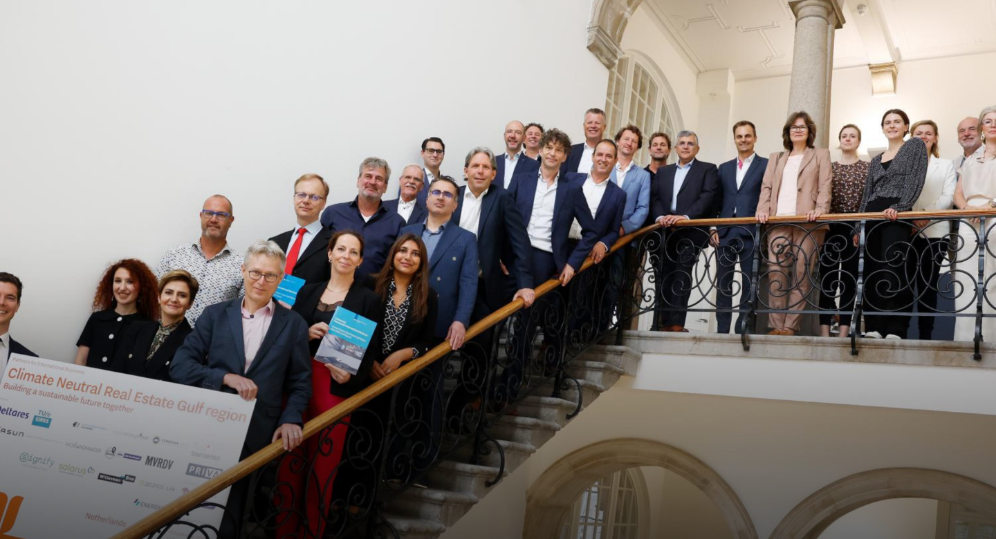 Members of the PIB stand on a flight of stairs and hold the signing board for this PIB