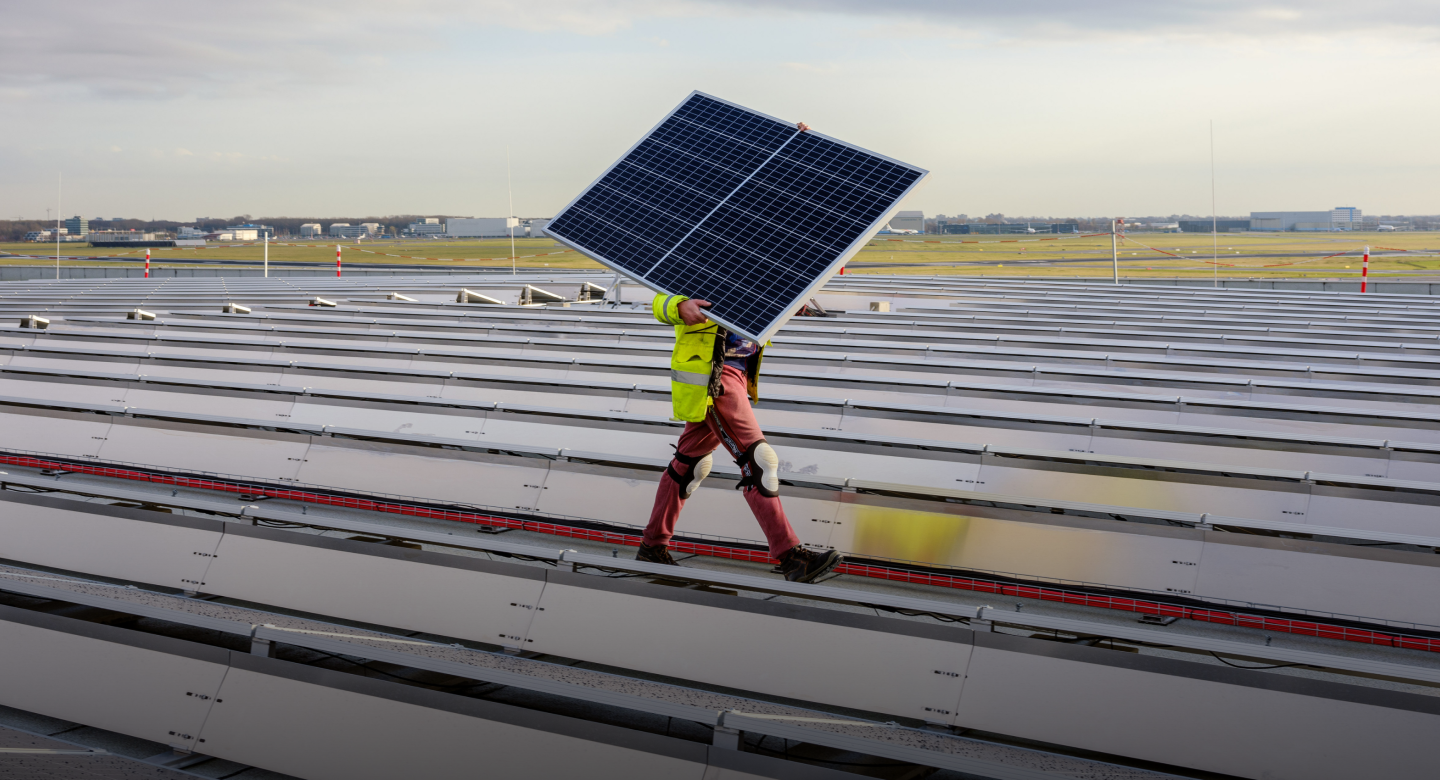 Man walking with solar panel on airport roof