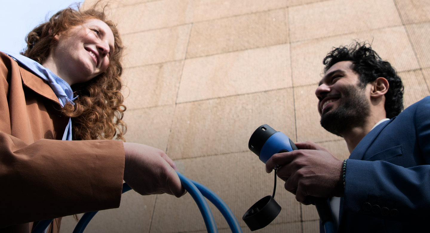 A couple holding an EV charging cable