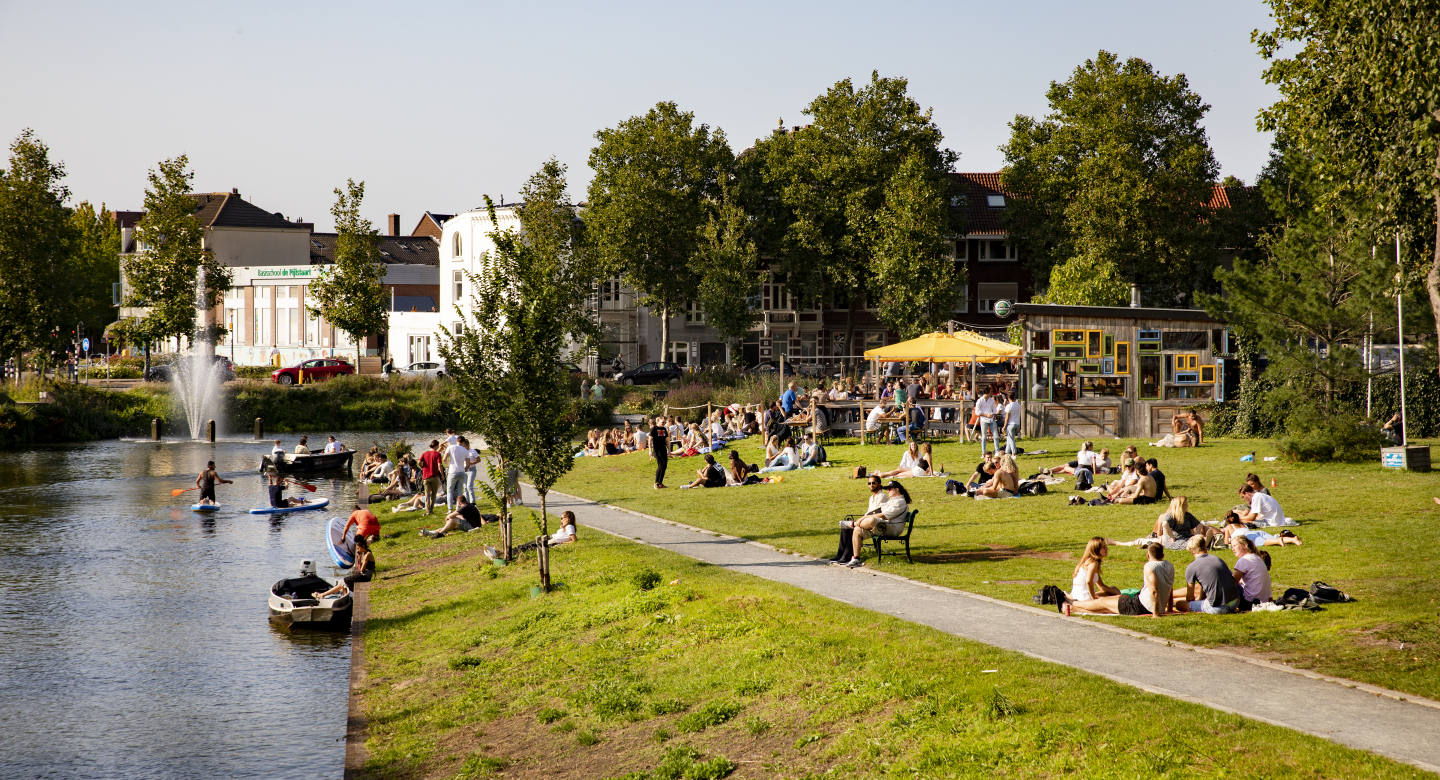 students on a lawn by a canal
