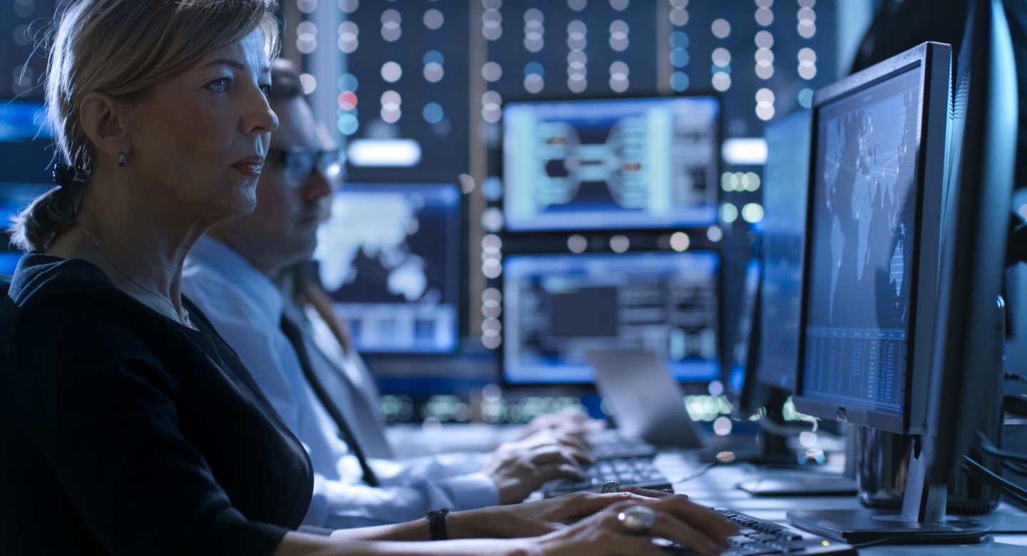 Woman sitting upright behind computer screen