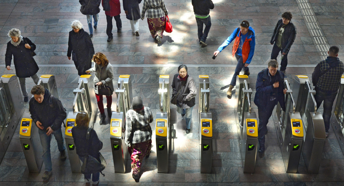 People in a train station at the OV check in gate 