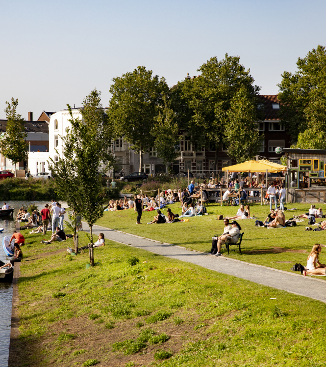 students on a lawn by a canal