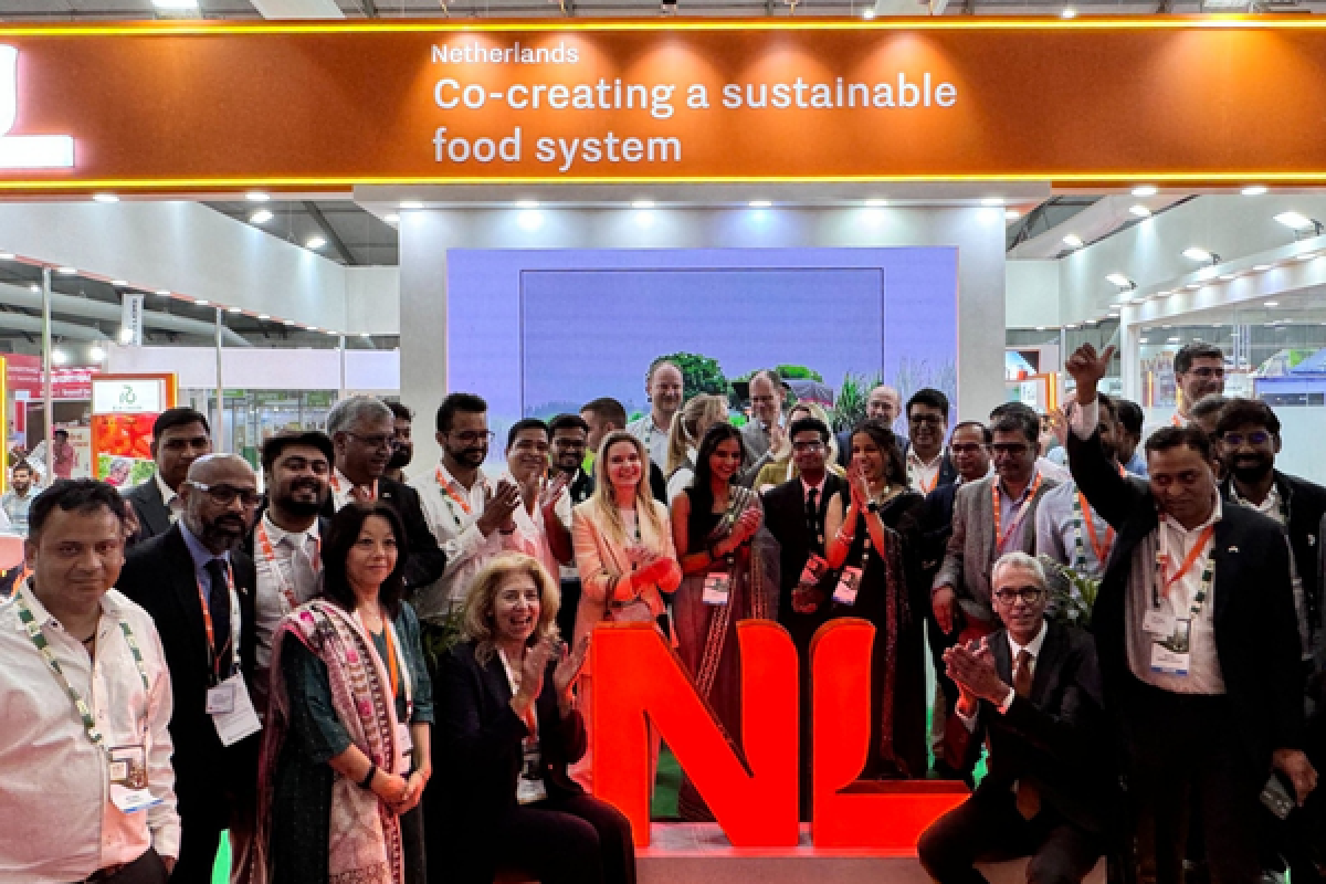 PIB members gathered around NL orange letters at a trade show