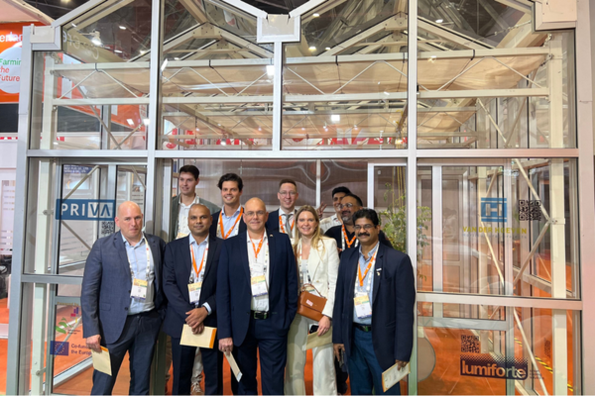 PIB members take a group picture with a greenhouse in the background