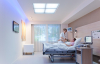 A doctor tends to a patient in a hospital room