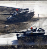 Two tanks with red flags on the top on rocky terrain